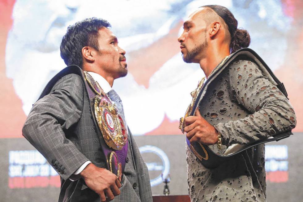 Manny Pacquiao, left, and Keith Thurman pose for pictures during a press conference ahead of th ...