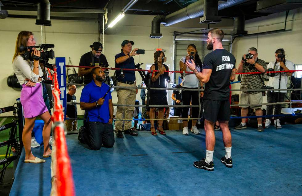 Boxer Caleb Plant, IBF super middleweight champion, center, gives an interview during a media d ...