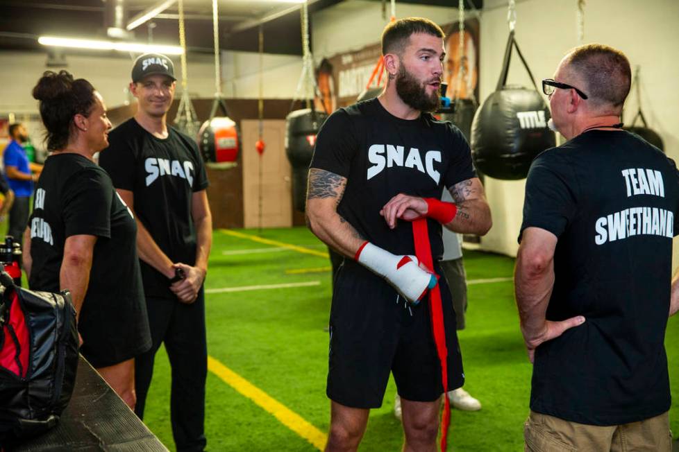 Boxer Caleb Plant, IBF super middleweight champion, center, confers with his father Richie Plan ...