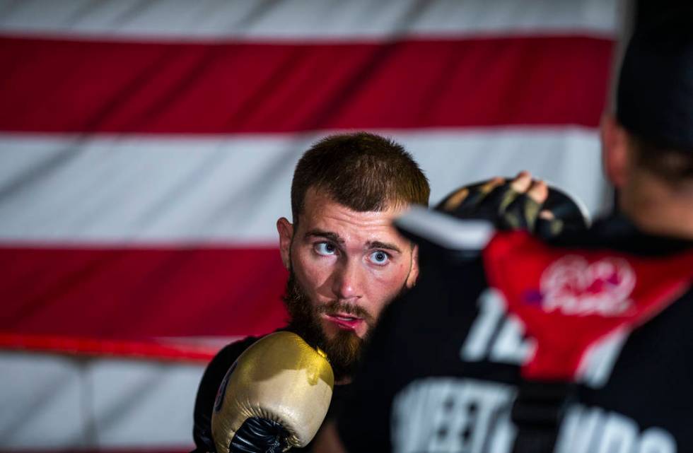 Boxer Caleb Plant, IBF super middleweight champion, punches a pad in the ring with trainer Just ...