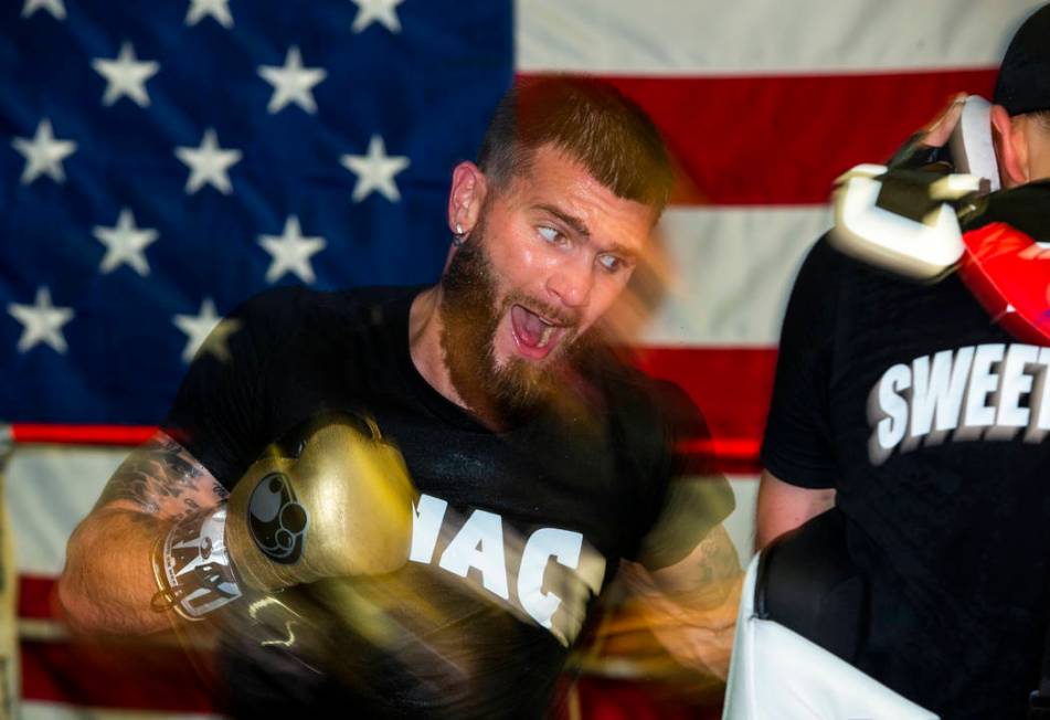 Boxer Caleb Plant, IBF super middleweight champion, left, readies to strike a pad held by train ...