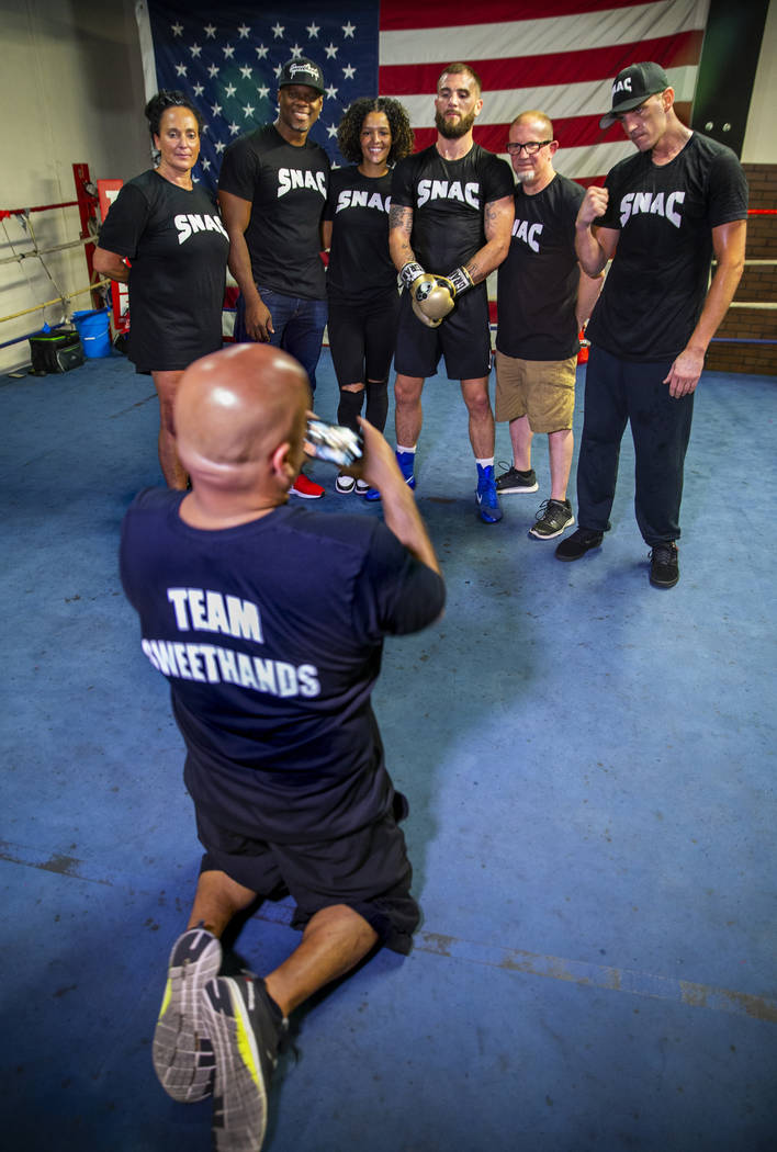 Boxer Caleb Plant, IBF super middleweight champion, center, is flanked by members of his team d ...