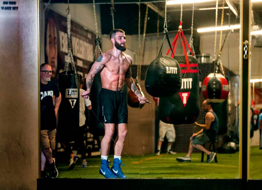 Boxer Caleb Plant, IBF super middleweight champion, right, jumps rope as his dad Richie, left, ...