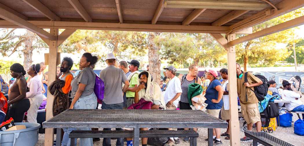 Residents wait in line for mattresses to sleep for the night at the Courtyard Homeless Resource ...