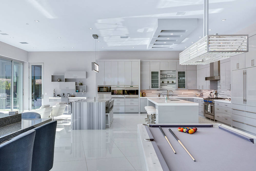 The kitchen leads into a living area, which has entertainment elements. (Ivan Sher Group)