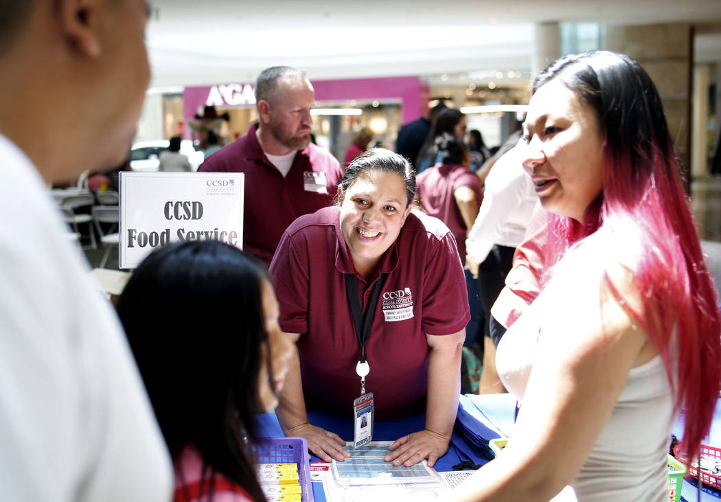 Laura Brown with Clark County School District food service speaks with a family during the annu ...