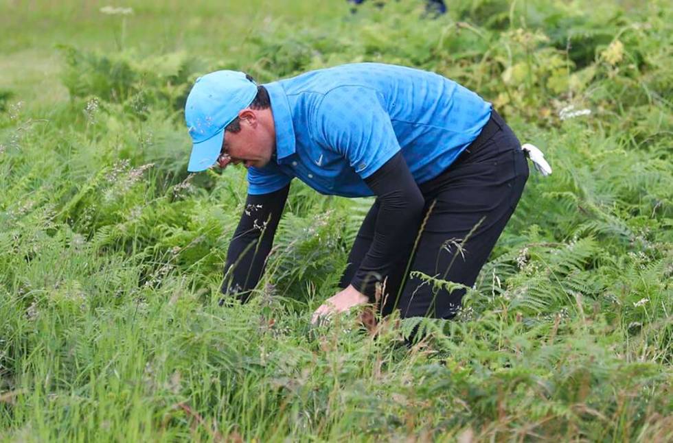 Northern Ireland's Rory McIlroy looks for his ball in the long rough on the 1st hole during the ...