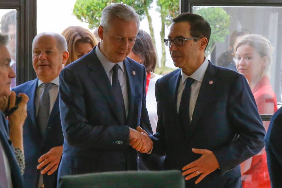 French Finance Minister Bruno Le Maire, left, shakes hands with US Treasury Secretary Steve Mnu ...