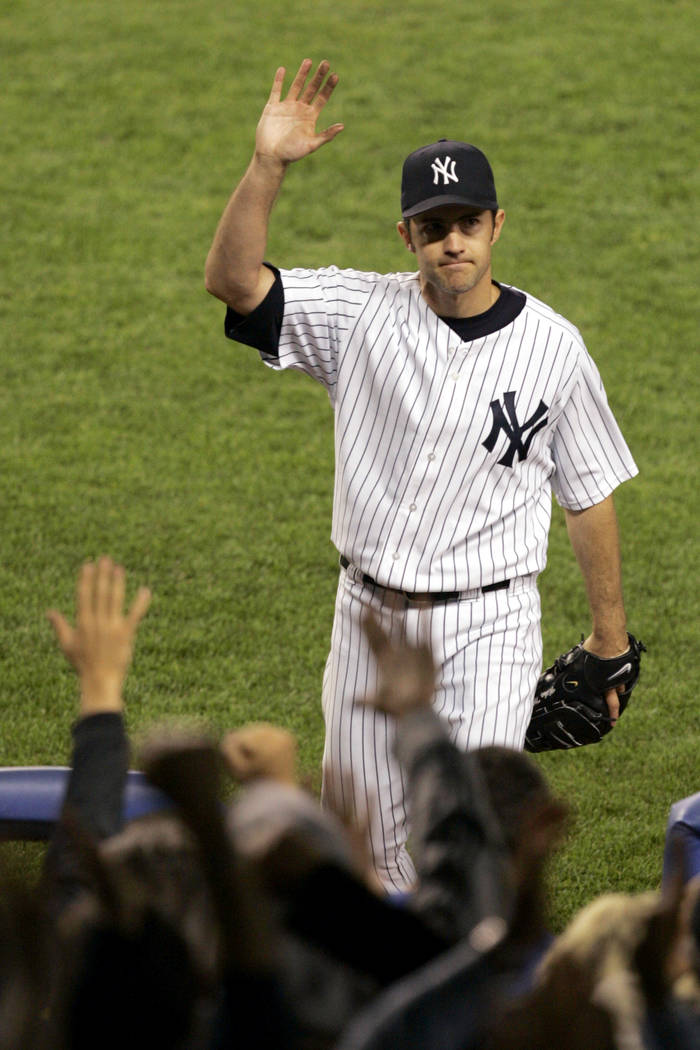 New York Yankees pitcher Mike Mussina waves to the crowd while leaving the game during the seve ...