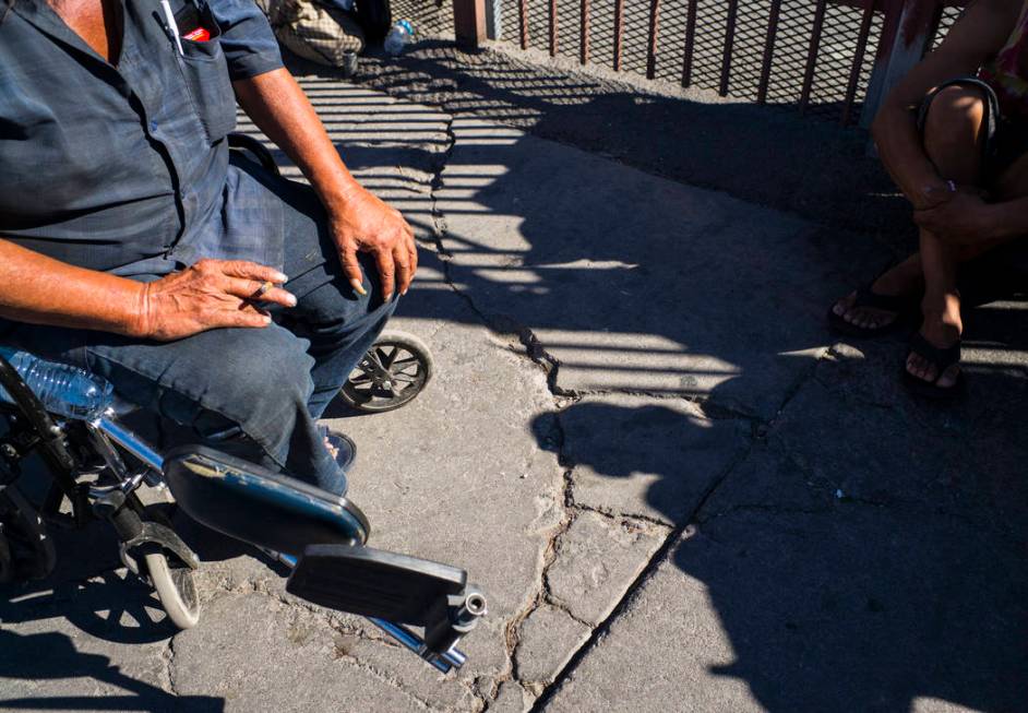 TJ, who declined to give his last name, left, talks about living homeless while waiting in line ...