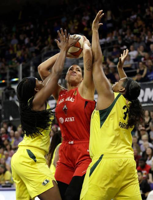 Las Vegas Aces' Liz Cambage, center, is doubled-teamed by Seattle Storm's Crystal Langhorne, le ...