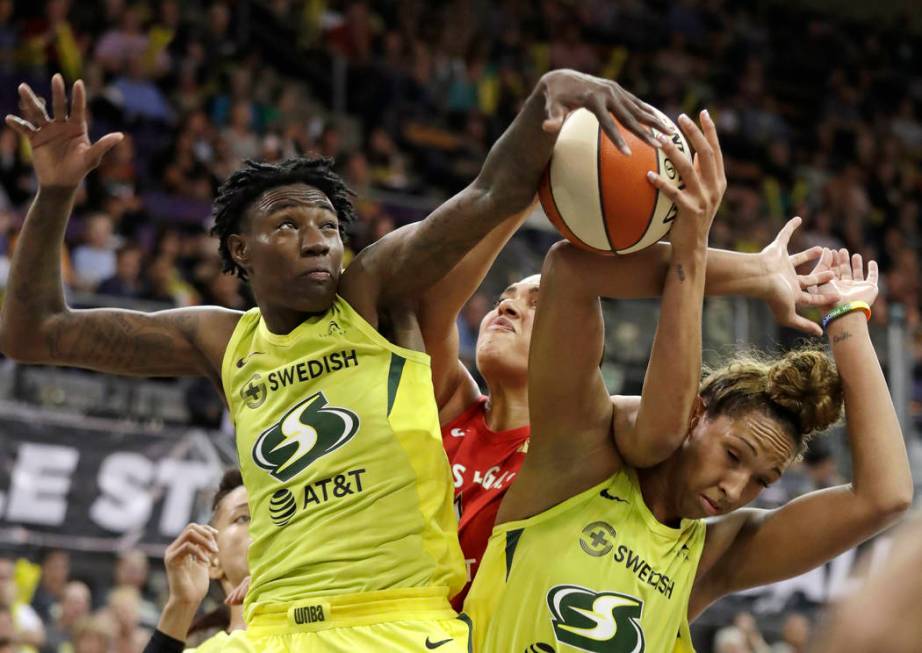 Seattle Storm's Natasha Howard, left, and Mercedes Russell, right, compete for a loose ball wit ...