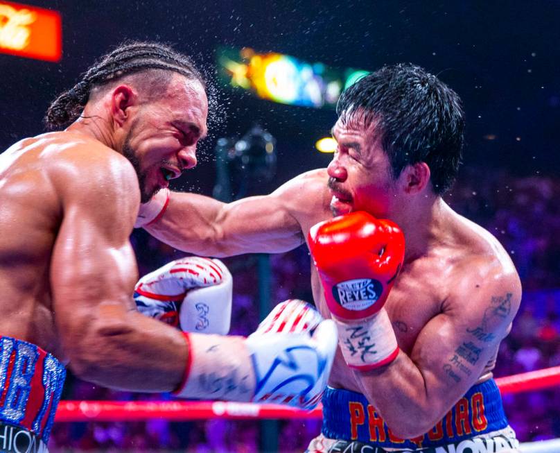 Keith Thurman, left, is punched in the face by Manny Pacquiao during Round 12 of their WBA supe ...