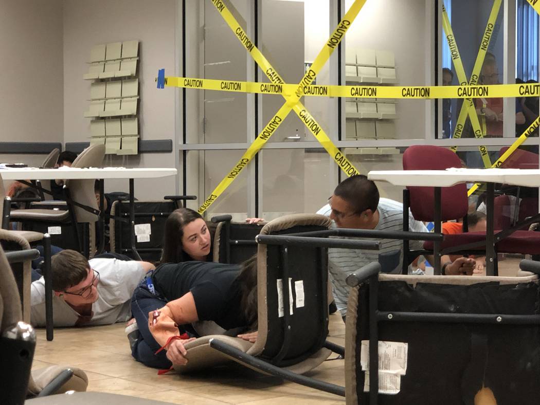 Volunteers pretending to be injured or hiding civilians participate in an active-shooter drill ...