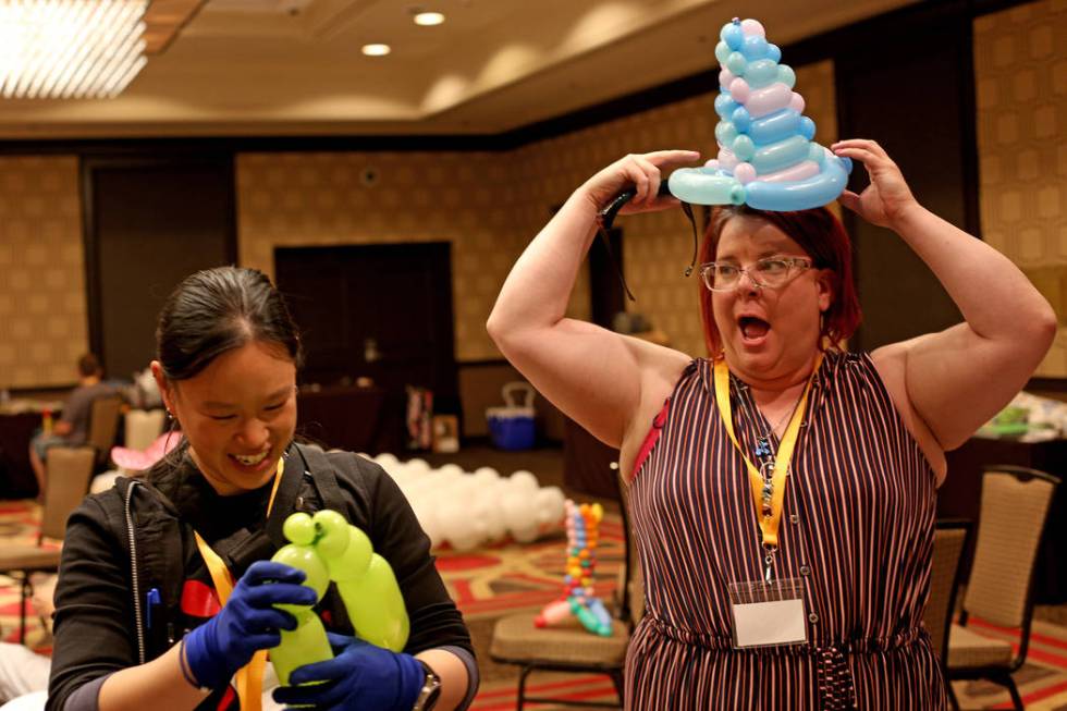 Angie Tsang, of California, left, and Becky Killoran of Canada, right, play with balloon twisti ...