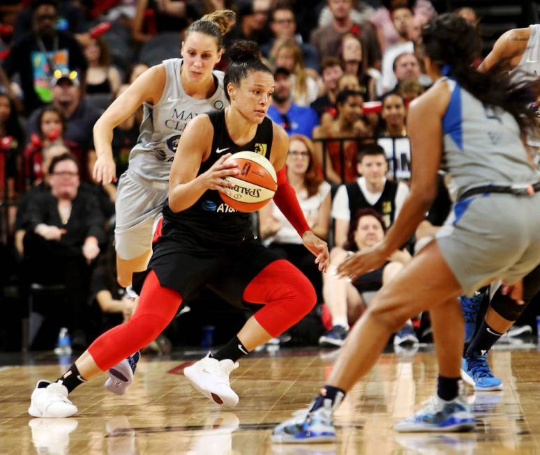 Las Vegas Aces point guard Kayla McBride (21) dribbles the ball against Minnesota Lynx guard Le ...