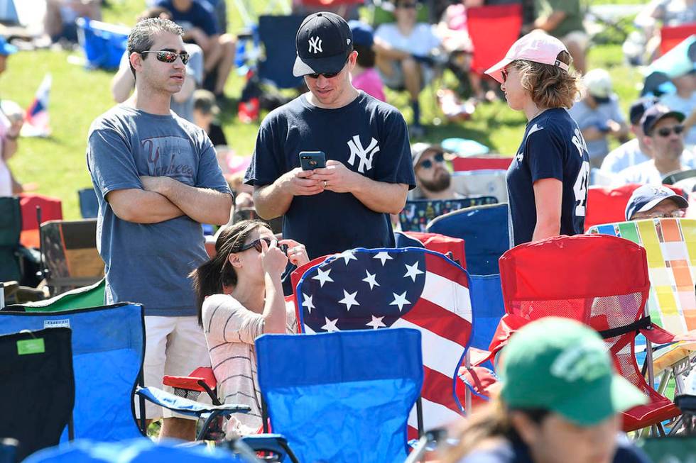 Fans wait for the start of the National Baseball Hall of Fame induction ceremony at the Clark S ...