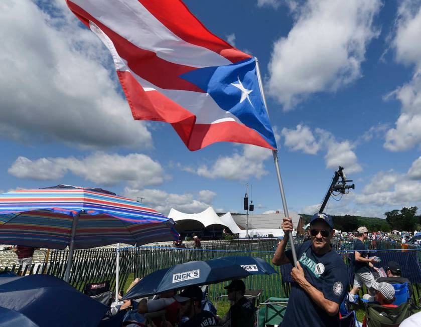 Miguel Rosario of Atlantic City, N.J., waves a Puerto Rican Flag while waiting for the start of ...