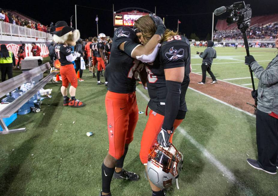 UNLV Rebels linebacker Javin White (16) and defensive lineman Roger Mann (56) share a hug after ...