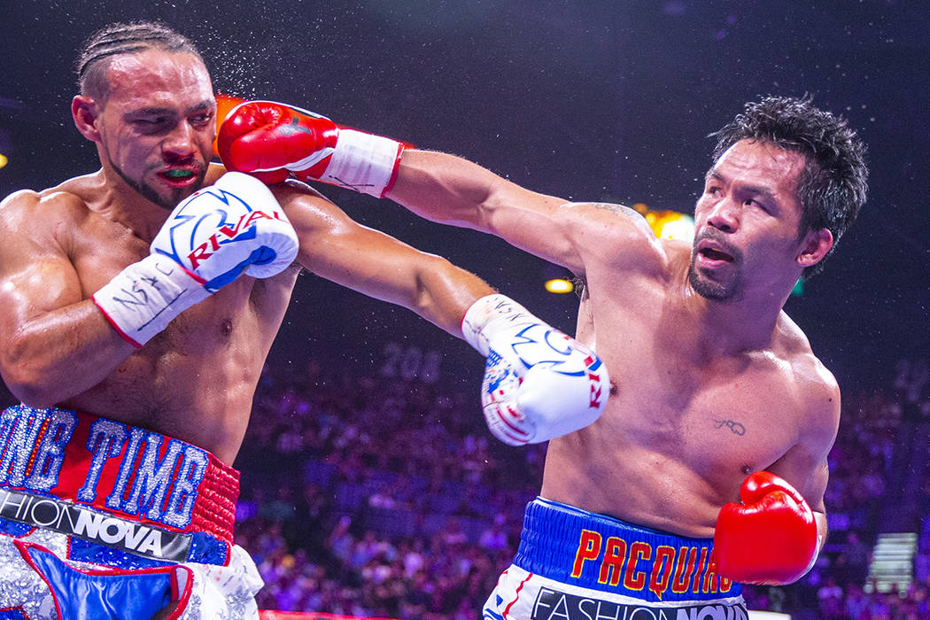 Keith Thurman is punched in the face by Manny Pacquiao during Round 5 of their WBA super welter ...