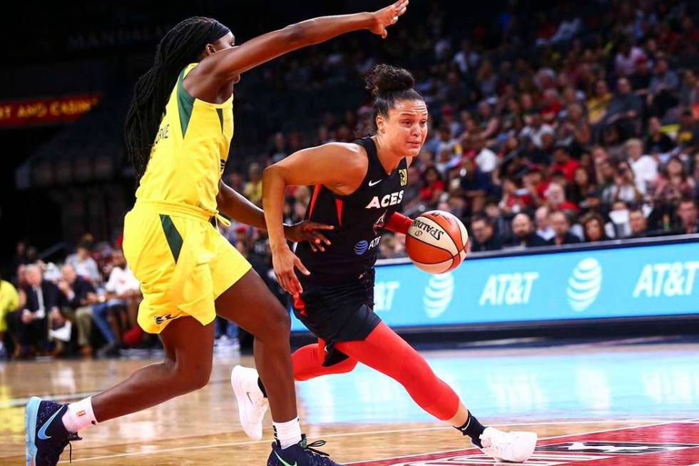 Las Vegas Aces' Kayla McBride, right, drives to the basket past Seattle Storm's Crystal Langhor ...