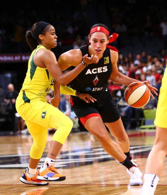 Las Vegas Aces' Dearica Hamby (5) drives to the basket past Seattle Storm's Jordin Canada durin ...