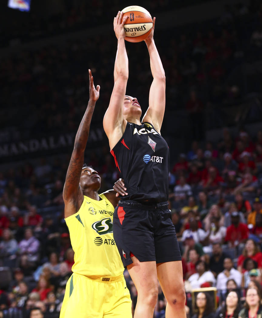 Las Vegas Aces' Dearica Hamby gets a rebound in front of Seattle Storm's Natasha Howard during ...