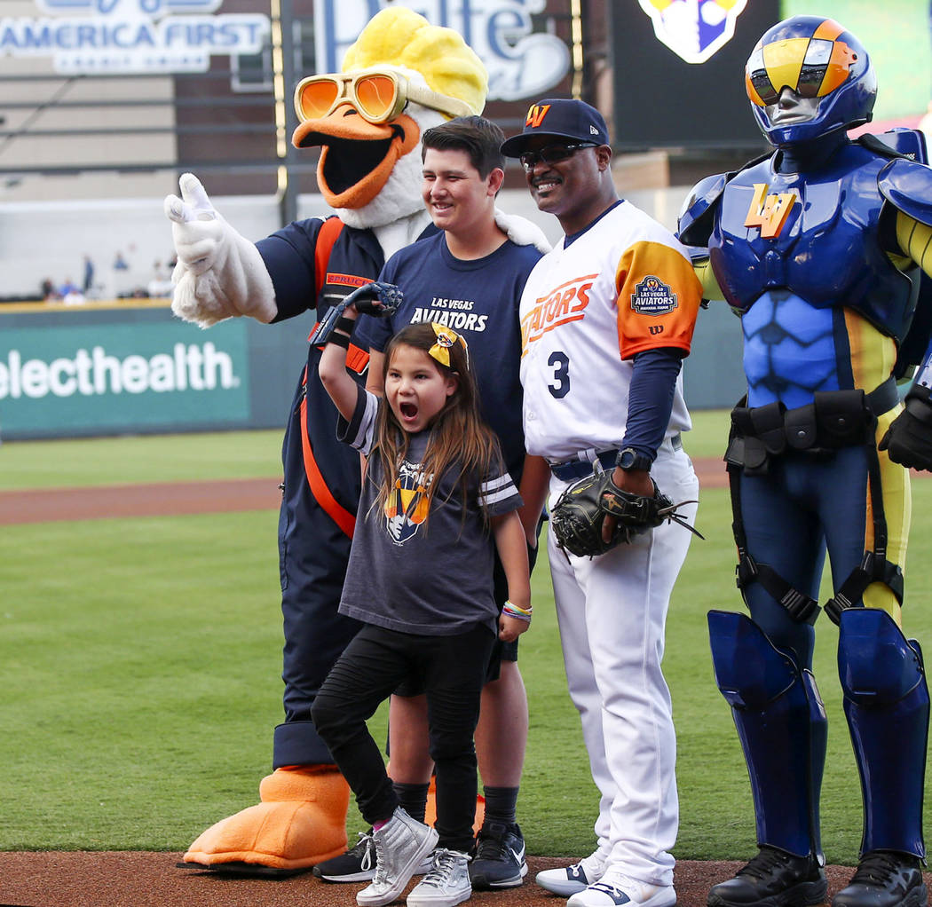 Nine-year-old Hailey Dawson, center, poses after throwing the first pitch with, from left, Spru ...