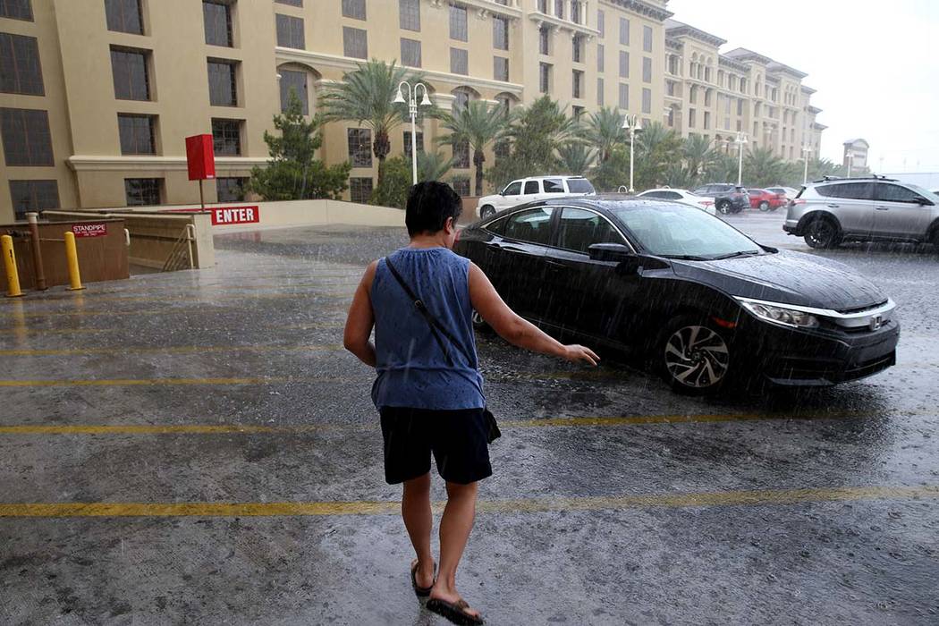 Keith Carbullido pulls up the car for his wife, Rosa Carbullido, in a downpour at Green Valley ...