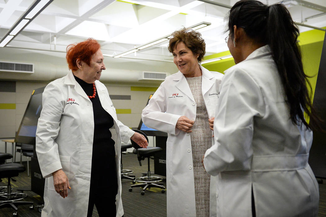 UNLV Medical School Dean Barbara Atkinson, left, gives Sen. Jacky Rosen, D-Nev., a white coat d ...