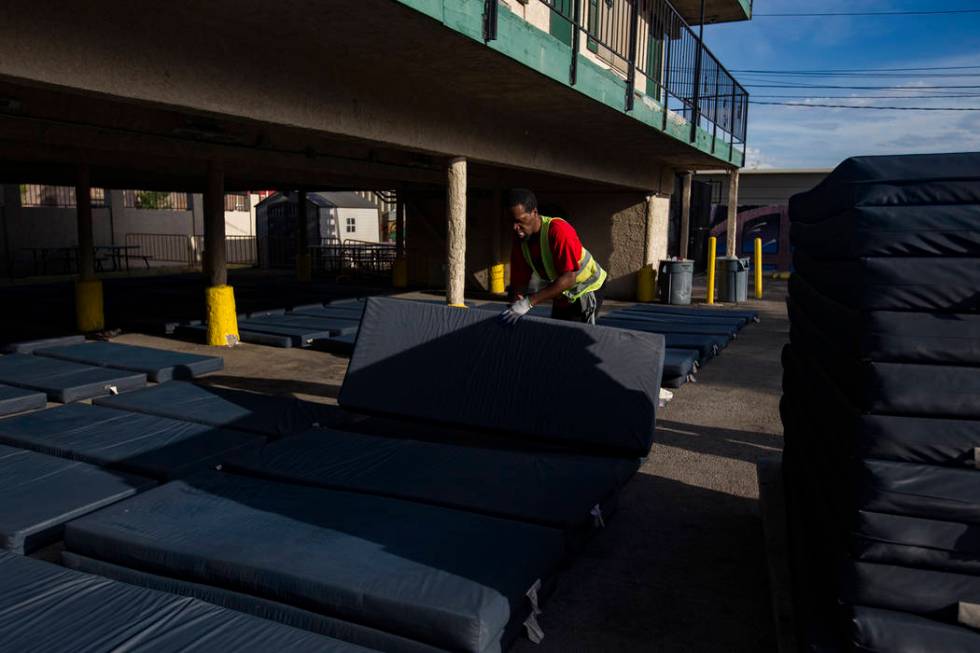 Chukwunedu Arah, a volunteer, places bed mats for clients at the Courtyard Homeless Resource Ce ...