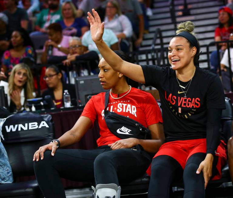 Las Vegas Aces' Kayla McBride, right, waves while sitting next to Las Vegas Aces' A'ja Wilson d ...