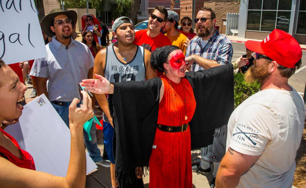 Melissa Akiima Eggstaff, middle, of Red Rage Protest for Kids in Cages, blocks her group from c ...