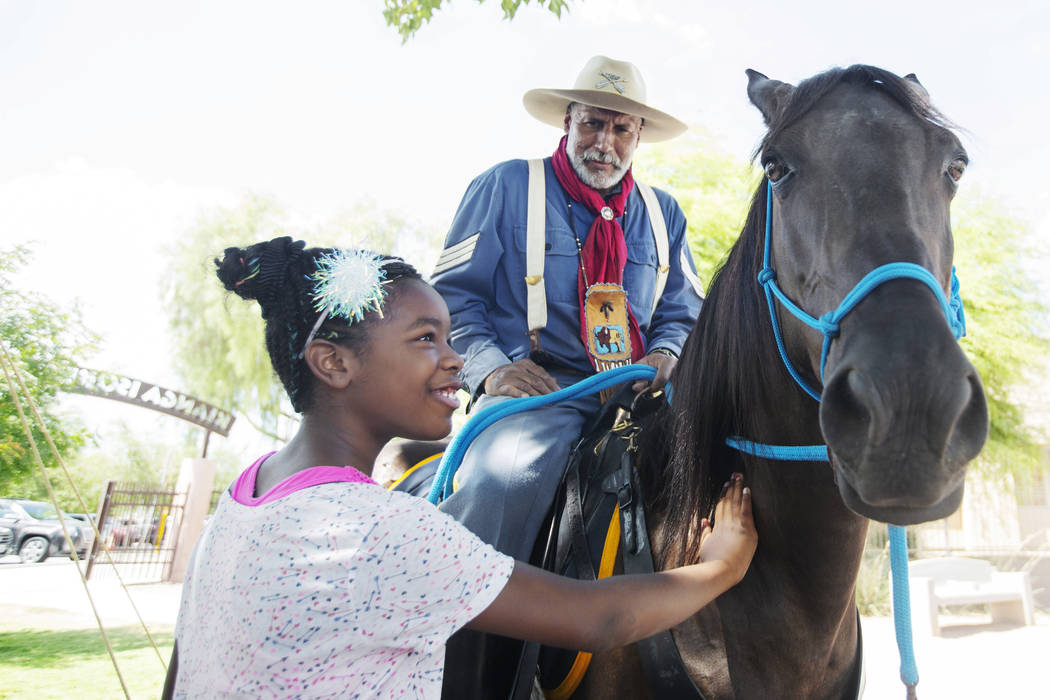 Tahji Moore, left, 9, pets the horse of Keith Hill, president trooper of the 9th and 10th Horse ...