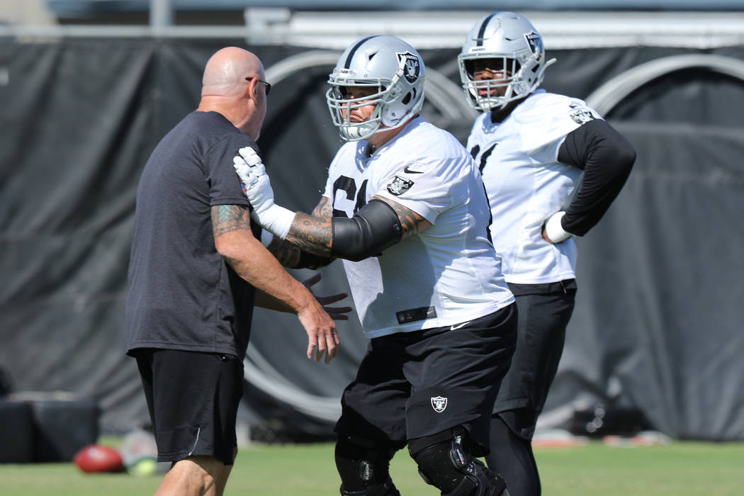 Oakland Raiders offensive line coach Tom Cable works with guard Richie Incognito (64), center, ...