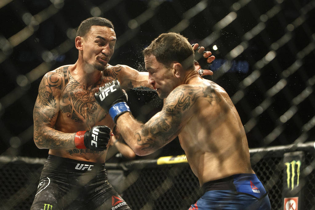 Max Holloway, left, fights Frankie Edgar during a mixed martial arts bout at UFC 240, in Edmont ...