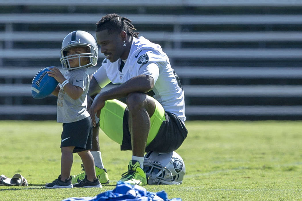 Oakland Raiders wide receiver Antonio Brown (84) plays on the sideline with his son Apollo, 23 ...
