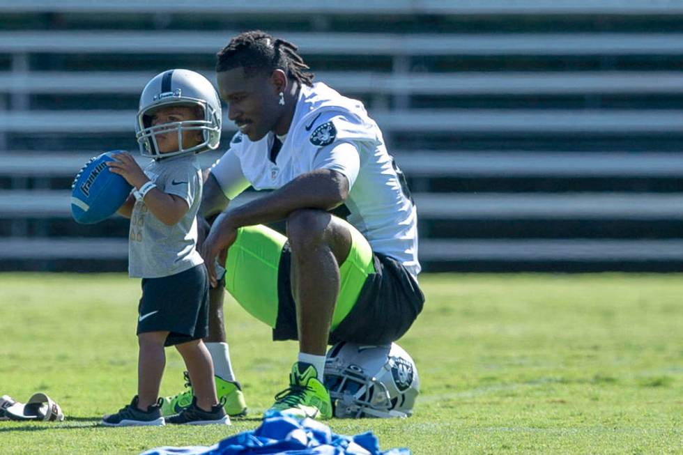 Oakland Raiders wide receiver Antonio Brown (84) plays on the sideline with his son Apollo, 23 ...