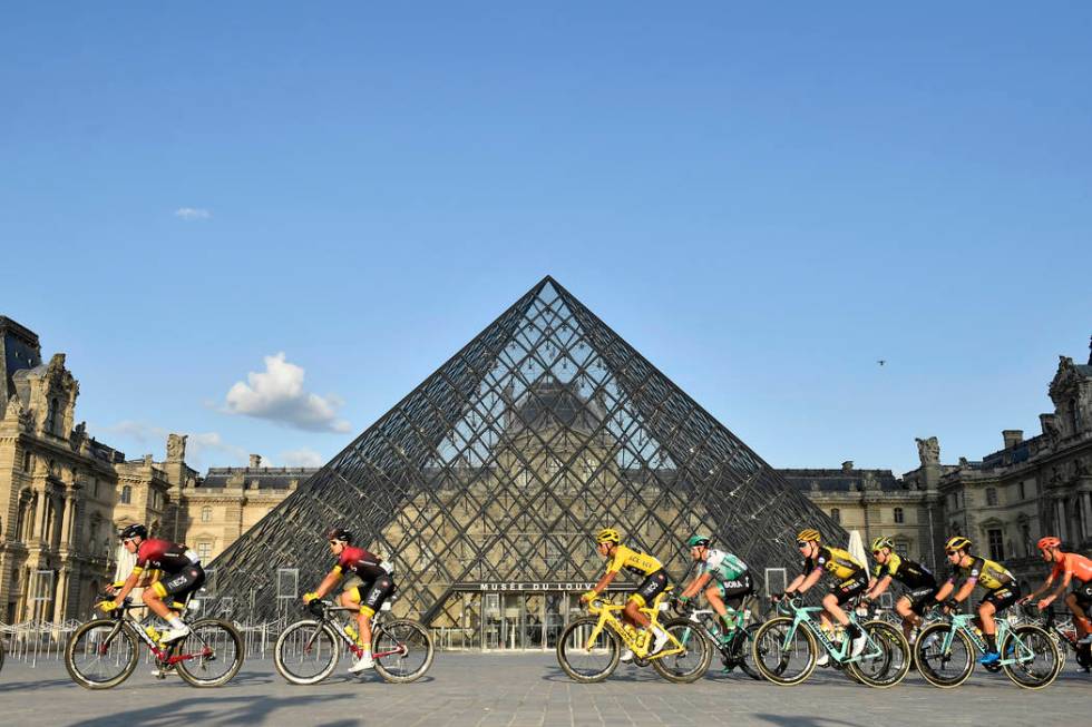 Colombia's Egan Bernal, center, wearing the overall leader's yellow jersey passes-by the pyrami ...