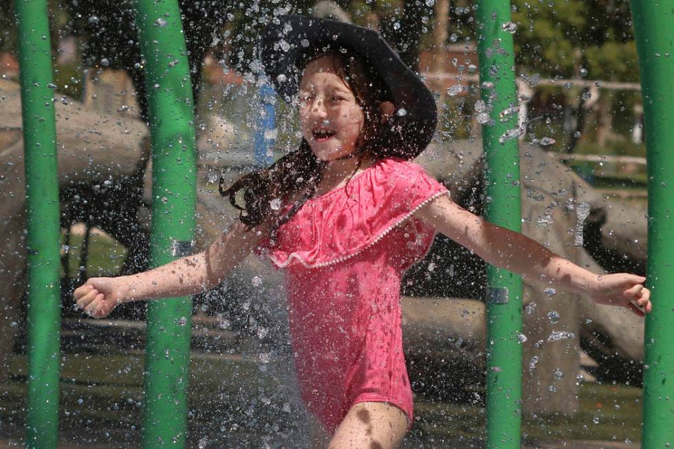 Elle Edwards, 7, cools herself as she plays at Sunset Park during a hot morning on Monday, July ...