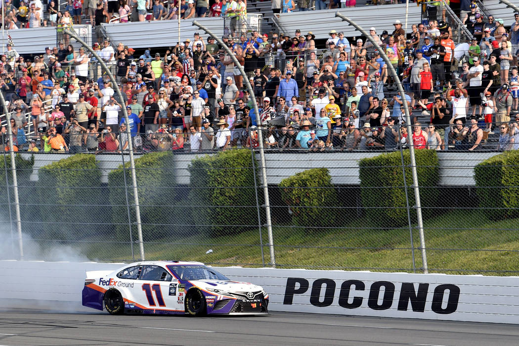 Denny Hamlin celebrates with a burnout after winning a NASCAR Cup Series auto race, Sunday, Jul ...