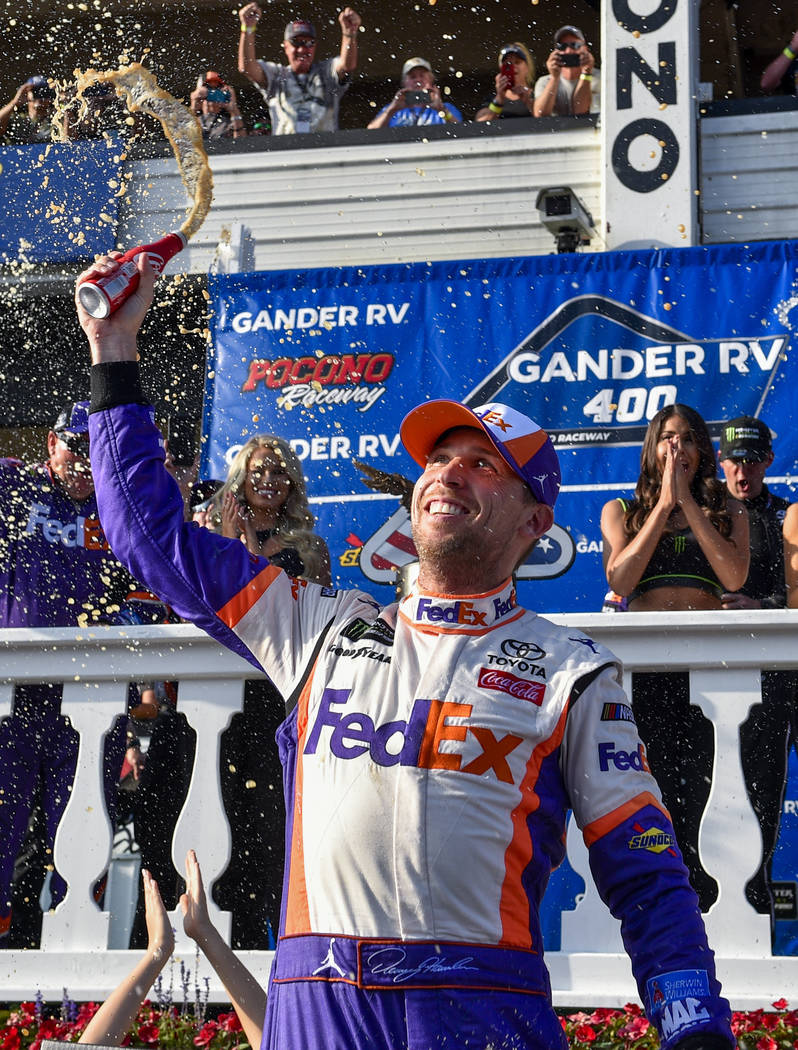 Denny Hamlin celebrates in Victory Lane after winning a NASCAR Cup Series auto race, Sunday, Ju ...