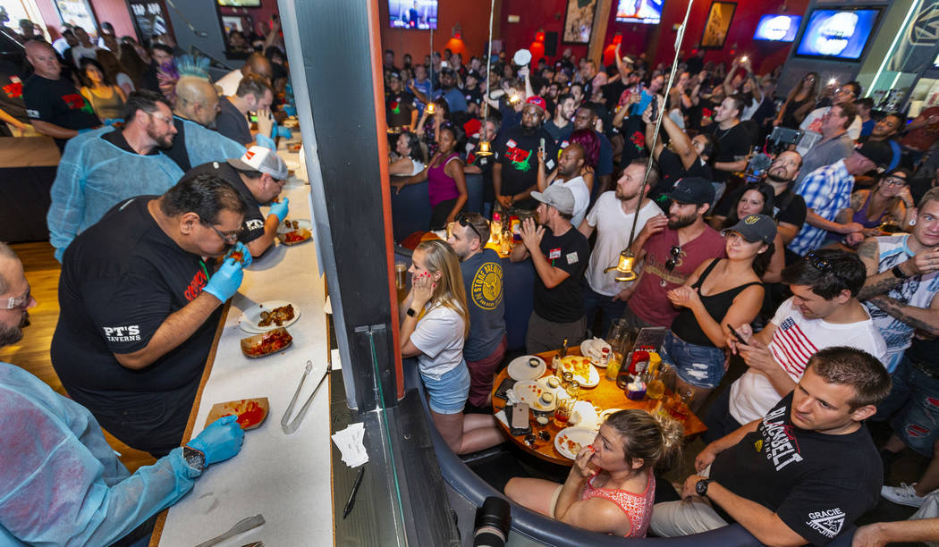 Competitors eat as supporters watch and cheer them on as PT's Ranch hosts a $4,000 wing-eating ...