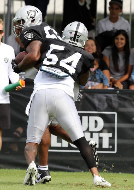 Oakland Raiders inside linebacker Brandon Marshall (54) tackles outside linebacker Vontaze Burf ...