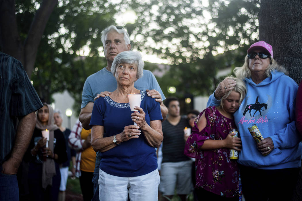 Susan Meyers and husband Michael Oshan listen to a hymn during a vigil for victims of a Sunday ...