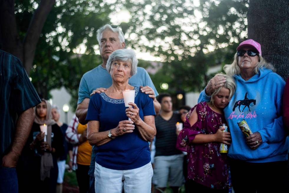 Susan Meyers and husband Michael Oshan listen to a hymn during a vigil for victims of a Sunday ...