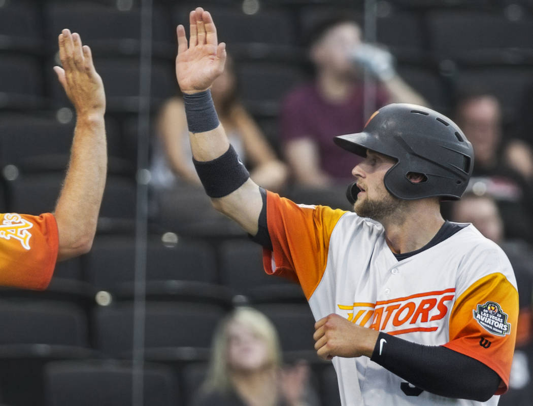 Las Vegas Aviators first baseman Seth Brown, right, high fives his teammates after scoring in t ...