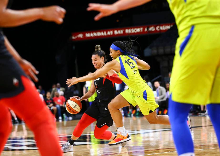 Las Vegas Aces' Kayla McBride (21) drives the ball under pressure from Dallas Wings' Allisha Gr ...