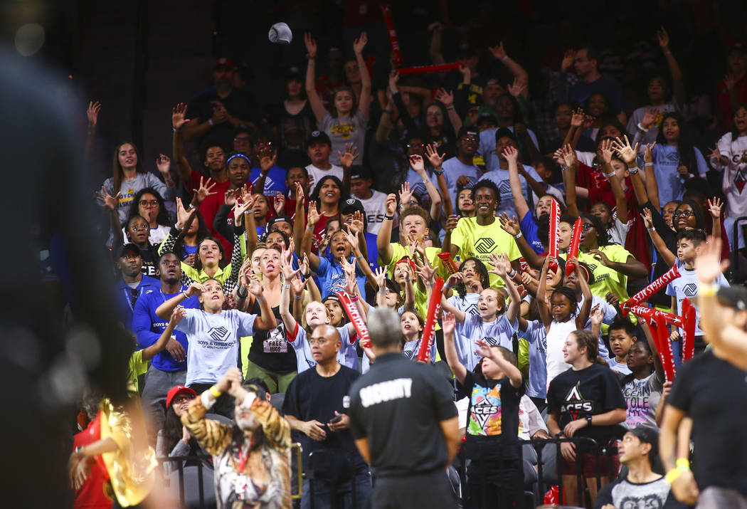 Las Vegas Aces fans reach for free items during the second half of a WNBA basketball game betwe ...