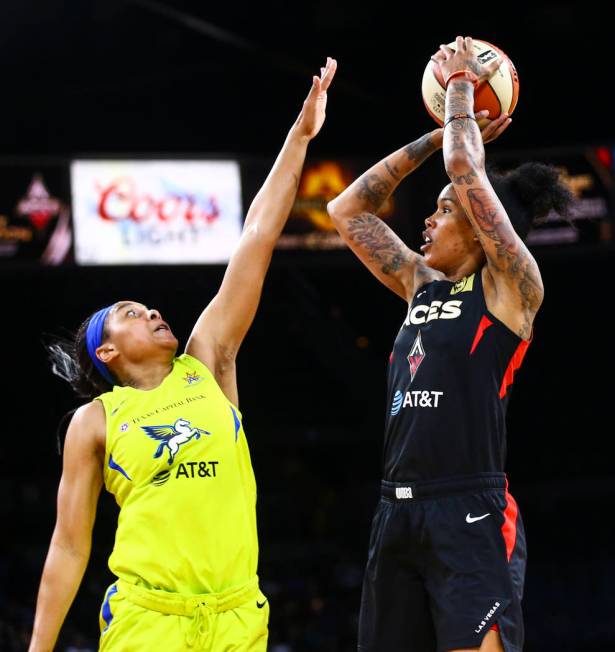 Las Vegas Aces' Tamera Young shoots over Dallas Wings' Allisha Gray during the second half of a ...